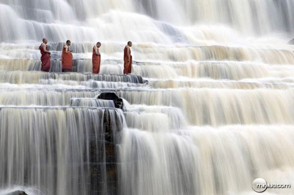 Buddhist monks chant at Pongour Falls, the largest waterfall in Dalat, Vietnam.